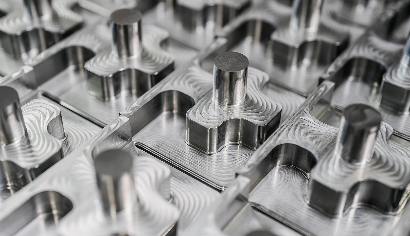 Verschiedene Werkstoffe für kubische CNC-Fertigung bei Biltec: Stahl, Aluminium und Edelstahl. Die Materialien symbolisieren die Vielseitigkeit und Qualität der Bearbeitungsmöglichkeiten.