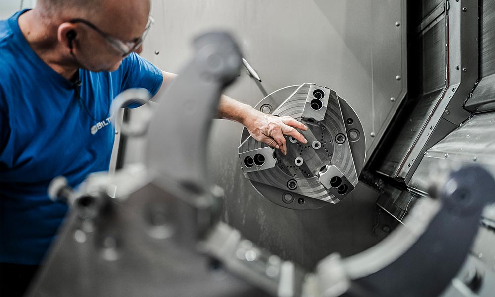 Innenansicht einer CNC-Maschine bei Biltec, spezialisiert auf rotative Fertigungen. Detailaufnahme zeigt Präzisionswerkzeuge und -komponenten in Aktion, verdeutlicht die technologische Expertise und Fertigungskompetenz im Bereich der rotativen CNC-Bearbeitung.
